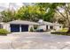 Spacious driveway leading to a white home with a dark garage and seating on the front porch at 120 W Trade Winds Rd, Winter Springs, FL 32708