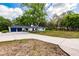 Long driveway leading to a charming white single story home surrounded by mature trees at 120 W Trade Winds Rd, Winter Springs, FL 32708