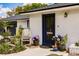 Charming home exterior featuring a blue front door, a white brick facade, and vibrant landscaping at 120 W Trade Winds Rd, Winter Springs, FL 32708