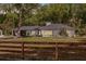 Charming ranch-style home with white brick, lush landscaping, and a wood fence at 120 W Trade Winds Rd, Winter Springs, FL 32708