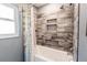 Updated bathtub shower with a white tub and tiled shower walls featuring decorative tile niches at 120 W Trade Winds Rd, Winter Springs, FL 32708