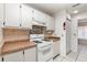 Bright kitchen features white cabinets, gas range, and wood-look countertops at 1230 Westside Dr, Winter Garden, FL 34787