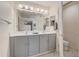 Bathroom with dual sinks, modern fixtures, and a large mirror reflecting natural light at 12711 Se 97Th Terrace Rd, Summerfield, FL 34491