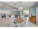 Open floor plan boasts a combined dining room and kitchen with white cabinets and modern appliances at 12711 Se 97Th Terrace Rd, Summerfield, FL 34491