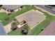 Lush lawns and mature landscaping surround the tan home with a well-maintained roof at 12711 Se 97Th Terrace Rd, Summerfield, FL 34491