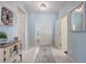 Bright and airy foyer with light blue walls, white tile flooring, and stylish decor at 12711 Se 97Th Terrace Rd, Summerfield, FL 34491