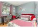 Cozy bedroom featuring a decorative pink-themed design with hardwood floors at 1303 Azalea Way, Winter Garden, FL 34787