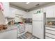 Functional kitchen featuring white cabinetry, a gas range, and a refrigerator at 1303 Azalea Way, Winter Garden, FL 34787