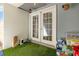 Cozy covered patio with artificial turf, double doors, and additional storage at 1303 Azalea Way, Winter Garden, FL 34787