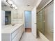 Bright bathroom with a large mirror, white vanity, tiled floors, and a shower with glass doors at 136 Bridgeview Ct, Longwood, FL 32779
