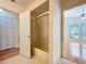 Bright bathroom featuring a shower with glass doors, vanity, and hardwood floors in the adjacent room at 136 Bridgeview Ct, Longwood, FL 32779