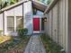 Charming home featuring a striking red front door, a stone pathway, and a distinctive exterior architecture at 136 Bridgeview Ct, Longwood, FL 32779