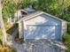 Spacious garage with stone accents and a paved driveway nestled among mature trees at 136 Bridgeview Ct, Longwood, FL 32779