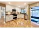 Modern kitchen with stainless steel appliances, granite countertops, white cabinets, and hardwood floors at 136 Bridgeview Ct, Longwood, FL 32779