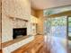 Cozy living room with a stone fireplace, built-in shelves, and sliding door access at 136 Bridgeview Ct, Longwood, FL 32779