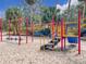 Vibrant community playground featuring various play structures, set in a sandy area surrounded by trees at 136 Bridgeview Ct, Longwood, FL 32779