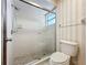 Bathroom shower with glass door, updated fixtures, patterned floor, and natural lighting at 136 Bridgeview Ct, Longwood, FL 32779