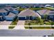 Aerial view of home featuring manicured yard, lush landscaping, a three car garage, and neighborhood lake views at 13828 Tybee Beach Ln, Orlando, FL 32827