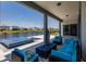 Covered patio with outdoor seating area and fire pit overlooking an exquisite pool and lake at 13828 Tybee Beach Ln, Orlando, FL 32827