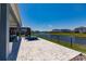 Backyard showcasing brick patio, lake view, and new construction neighborhood at 13828 Tybee Beach Ln, Orlando, FL 32827