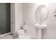 Bathroom featuring modern pedestal sink and marble floors, perfect for guests at 13828 Tybee Beach Ln, Orlando, FL 32827