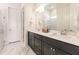 Bathroom featuring a double sink vanity with dark cabinets and marble-look floors at 13828 Tybee Beach Ln, Orlando, FL 32827