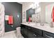 Bathroom featuring double vanity sinks, marble floors, and dark gray accent wall at 13828 Tybee Beach Ln, Orlando, FL 32827