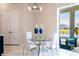 Bright dining room features an modern light fixture, glass table and views of the back yard at 13828 Tybee Beach Ln, Orlando, FL 32827