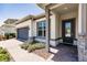 Inviting front porch featuring elegant stone accents, a stylish front door, and a brick walkway at 13828 Tybee Beach Ln, Orlando, FL 32827