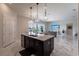 Spacious kitchen with dark cabinets, large island, stainless appliances, and open layout to living area at 13828 Tybee Beach Ln, Orlando, FL 32827
