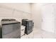 Well-equipped laundry room featuring modern washer and dryer set, wire shelving, and marble tile flooring at 13828 Tybee Beach Ln, Orlando, FL 32827