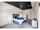 Stylish main bedroom featuring a gray upholstered bed frame and a striking dark-painted ceiling at 13828 Tybee Beach Ln, Orlando, FL 32827