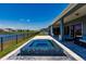 Stunning pool with lake view, covered patio, outdoor seating and manicured lawn at 13828 Tybee Beach Ln, Orlando, FL 32827