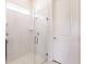 A glass shower features white tile and a built-in shelf, offering a clean and modern design at 13828 Tybee Beach Ln, Orlando, FL 32827