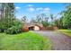 Quaint home featuring a gravel driveway and fenced front yard with mature trees at 14143 Conifer Dr, Orlando, FL 32832