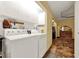 Functional laundry room with washer, dryer, and ample storage cabinets, leading to a hallway and closet at 14143 Conifer Dr, Orlando, FL 32832