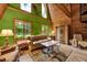 Living room with striking green accent wall, wood paneling, and natural light from large windows at 14143 Conifer Dr, Orlando, FL 32832
