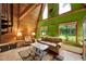 Living room with high wood ceilings, green accent walls, and a large window overlooking the backyard at 14143 Conifer Dr, Orlando, FL 32832