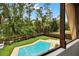 Aerial view of a spacious in-ground pool in a lush, fenced backyard at 14143 Conifer Dr, Orlando, FL 32832