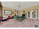 Inviting sun room featuring tile flooring, decorative wall hangings, comfortable seating, and a ceiling fan at 14143 Conifer Dr, Orlando, FL 32832