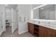 Bright bathroom featuring double vanity, wood cabinets, and large illuminated mirror at 14501 Grove Resort Ave # 2103, Winter Garden, FL 34787