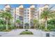 Beautiful exterior view of a multi-story condo building with tropical landscaping and a central water feature, creating an inviting atmosphere at 14501 Grove Resort Ave # 2103, Winter Garden, FL 34787