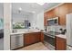 Stylish kitchen featuring stainless steel appliances, wood cabinets, and an open view to the living area for seamless entertaining at 14501 Grove Resort Ave # 2103, Winter Garden, FL 34787