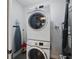 Convenient laundry room featuring a stacked washer and dryer with ironing board at 14501 Grove Resort Ave # 2103, Winter Garden, FL 34787