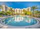 Beautiful pool area with surrounding palm trees and comfortable lounge chairs at 14501 Grove Resort Ave # 2103, Winter Garden, FL 34787