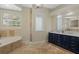 Bathroom has travertine floors, a double vanity, and a tub at 1570 Westover Loop, Lake Mary, FL 32746