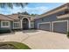 Exterior showcasing the two-car garage, tile roof, arched entryway, and expansive driveway at 1570 Westover Loop, Lake Mary, FL 32746