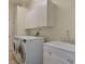 Functional laundry room with white cabinetry, a utility sink, and modern washer and dryer units at 1570 Westover Loop, Lake Mary, FL 32746