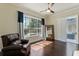 Living room has hardwood floors, a large window, a dark chair, a fireplace, and a door to another room at 1570 Westover Loop, Lake Mary, FL 32746