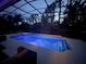 A beautifully lit screened-in pool at night, offering a serene and inviting atmosphere at 1570 Westover Loop, Lake Mary, FL 32746